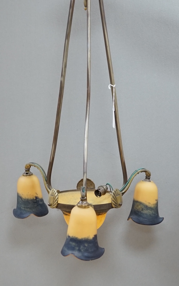 A French Art Deco brass three branch hanging light, with Muller Frere style glass shades, 75cm high. Condition - good